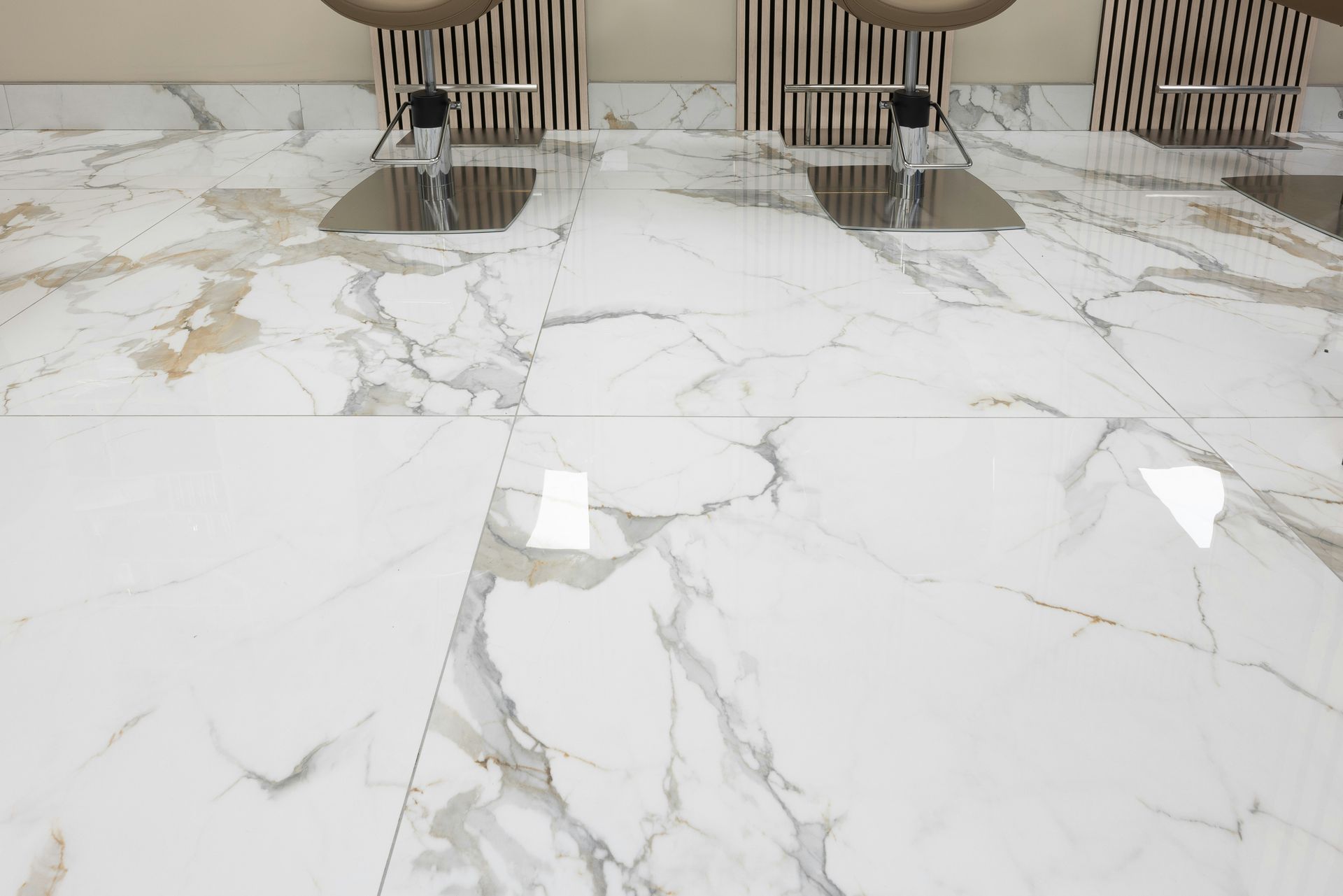 three chairs sitting on a marble floor in a room
